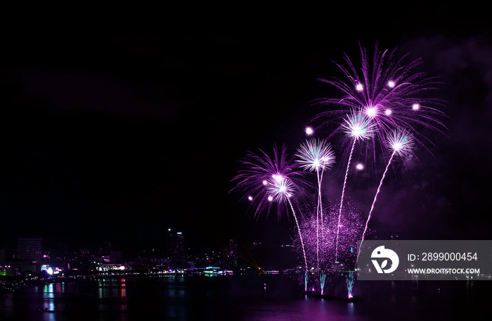 Impressive vivid purple color fireworks splashing in the night sky over the harbor