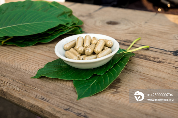 capsule on kratom leaf (Mitragyna speciosa) Mitragynine on wooden ,Drugs and Narcotics,Thai herbal which encourage health