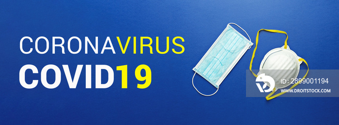 Two types of protective face masks on blue background with inscription CORONAVIRUS COVID-19. Protective masks as precaution in spread of coronavirus Covid-19 around world, banner, flat lay