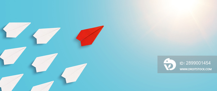 Red origami paper plane flies in front of the white plane. Leading organization towards its goals.