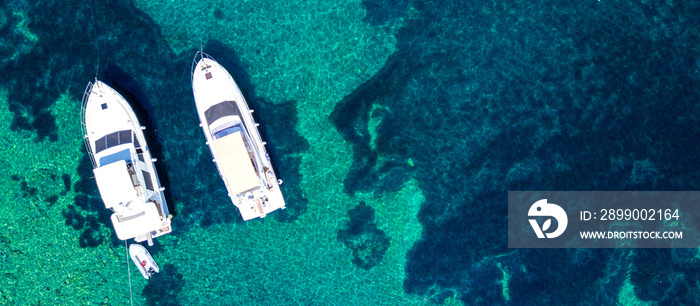 Aerial view of two yachts and clear turquoise sea