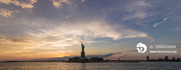 dramatic panorama of Statue of Liberty during sunset