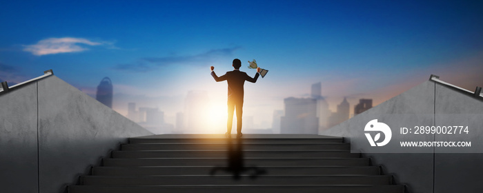 success businessman winner holding award, champion, victory and prize on stair with city background