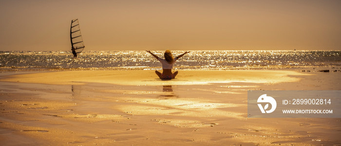 Banner header for tourist and summer holiday vacation people lifestyle. Enjoyed and overjoyed female viewed from back sitting on the sand at the beach with ocean and golden sunset in background