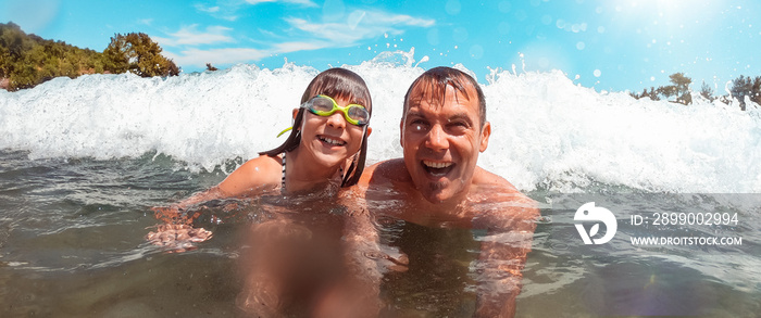 Men getting splashed by the sea wave