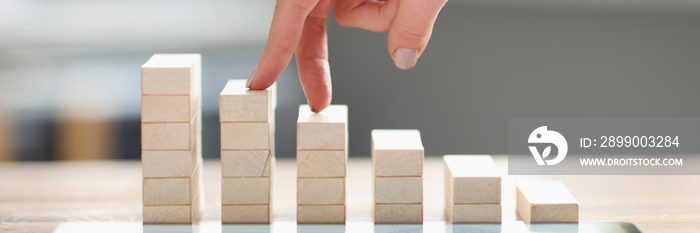 Women fingers climb up wooden block closeup