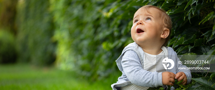 Freedom, recreation and childhood concept. Happy child outdoors, enjoying warm summer day on green lawn in cottage yard.