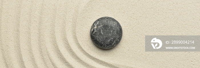 Stone on sand with lines, top view. Zen concept