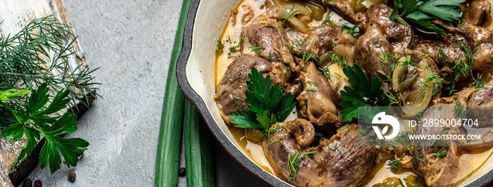 Stewed chicken stomach in pan. Traditional Korean spicy chicken meat on a dark background. Food recipe background. Close up