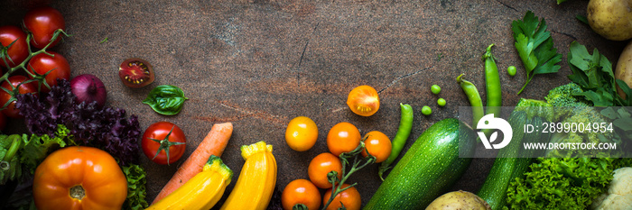 Organic farmer vegetables on dark slate table. Long banner format.