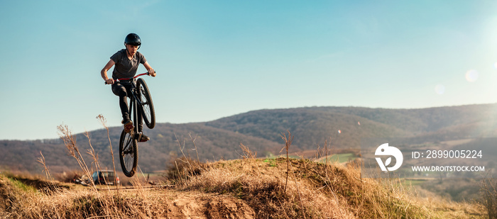 Dirt bike rider jumping in bike park on mountain bike