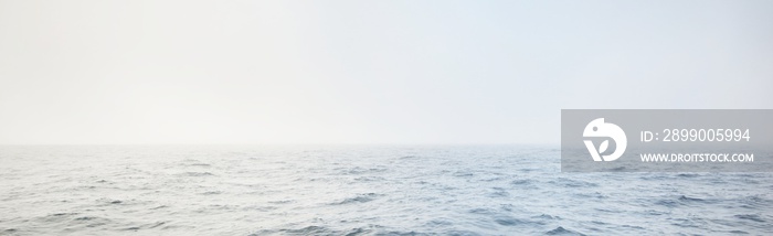 Baltic sea in a morning fog at sunrise, Sweden. View from a sailing boat. Soft golden sunlight, glowing clouds, golden hour. Picturesque panoramic scenery. Nature of Scandinavia