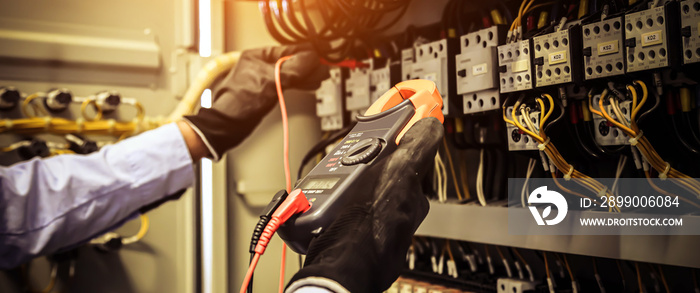 Electricity and electrical maintenance service, Engineer checking electric at circuit breaker and cable wiring system for repairing main power distribution board.