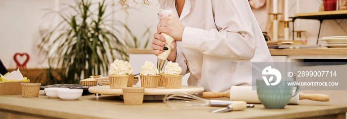 confectioner squeezes out a white cream in the form of roses flowers. process of decorating cupcakes with white whipped cream. Decorating a white cake with cream from the pastry bag.