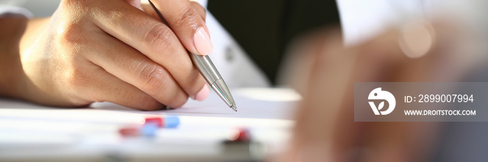 Female hand holds pen and makes notes lie next to tablet. Prescriptions for medicines concept