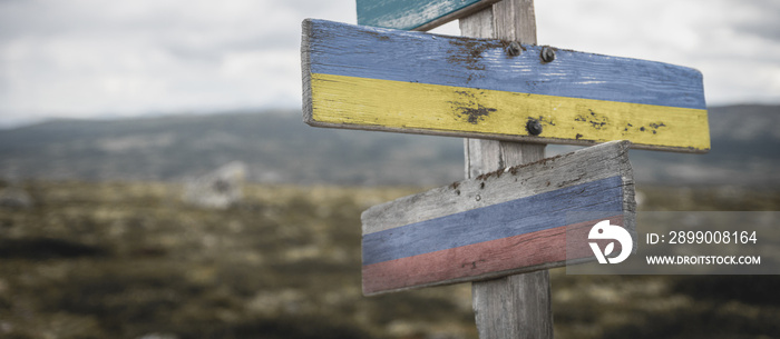 nato, ukraine and russia flag on signpost outdoors in nature.