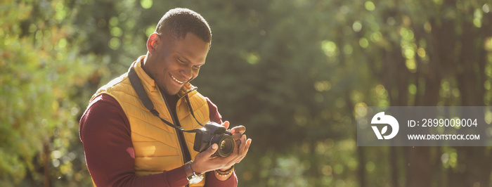 Banner african american guy photographer taking picture with photo camera on city green park copy space and place for text - leisure activity, diversity and hobby concept