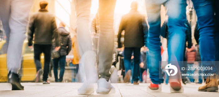 Crowd of people walking in motion in downtown rush hour