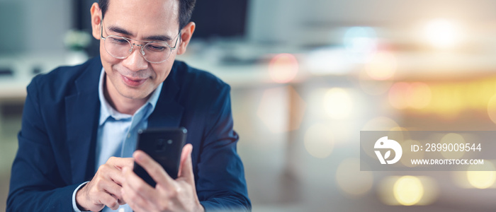 Businessman using smartphone and laptop, view taken from elephant side.