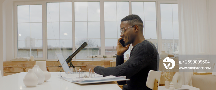 African American male remote working from home, having work phone call. Stay home, quarantine remote work