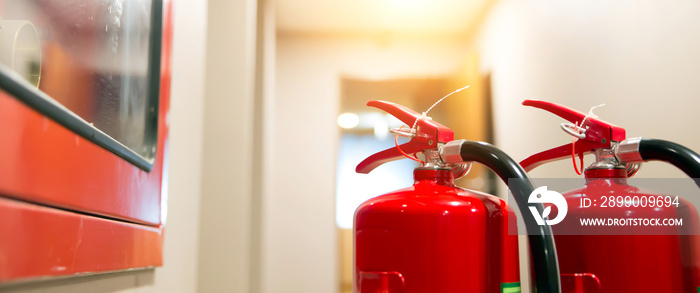 Red fire extinguisher tank at the exit door in the building concepts of emergency safety for fire prevention rescue and fire services concetps.