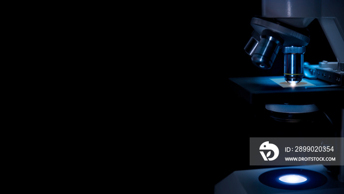 Microscope in labor in dark blue  light  and black background.