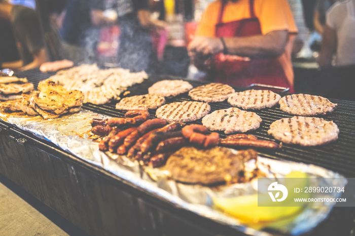 Street food barbecue burgers and sausages preparation.