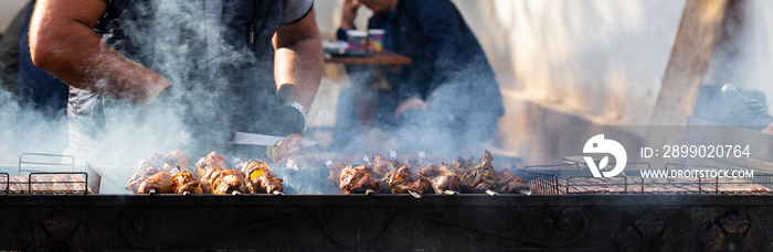 Roasting meat on the grill. Cooking fast food on the street.