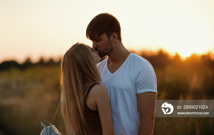 Romantic Couple at Sunset. Two people in love at sunset or sunrise. Man and woman on field