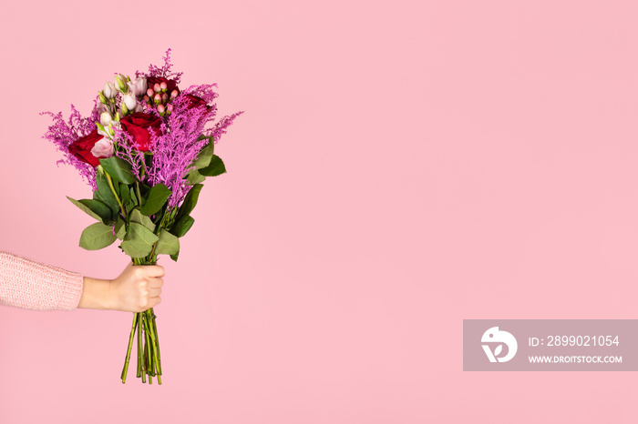 Woman holding bouquet with roses and eustoma flowers.