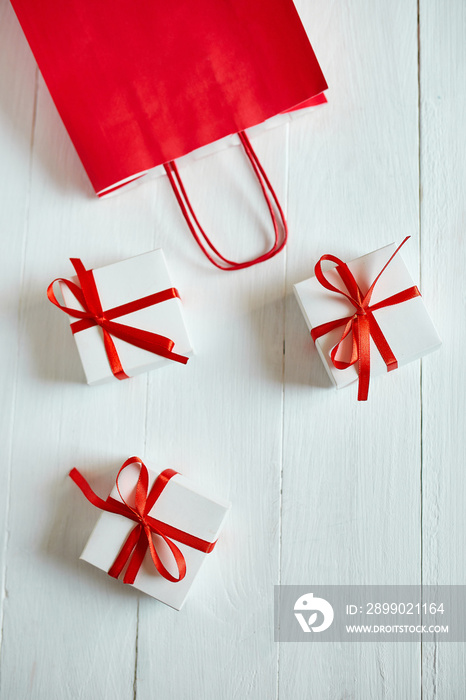 Gift boxes out from red paper bag on white background. Romantic Valentines day present, red and whit