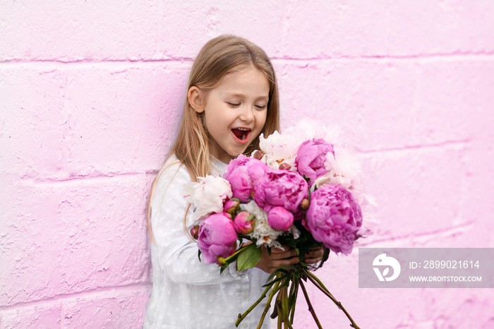 Portrait of a little girl with the peonies