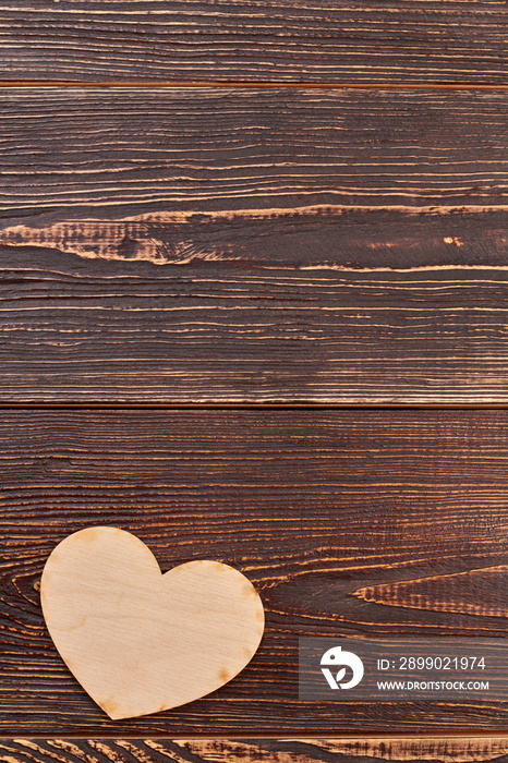 Plywood heart on brown wooden background. Blank wooden heart for decoupage and copy space.