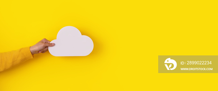 Cloud computing concept, hand holding cloud over yellow background, cloud storage, panoramic image