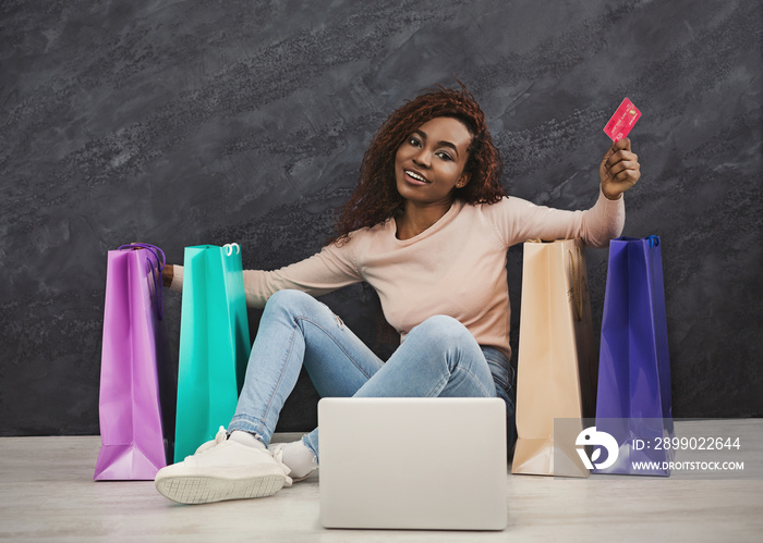 Young african woman shopping online at home