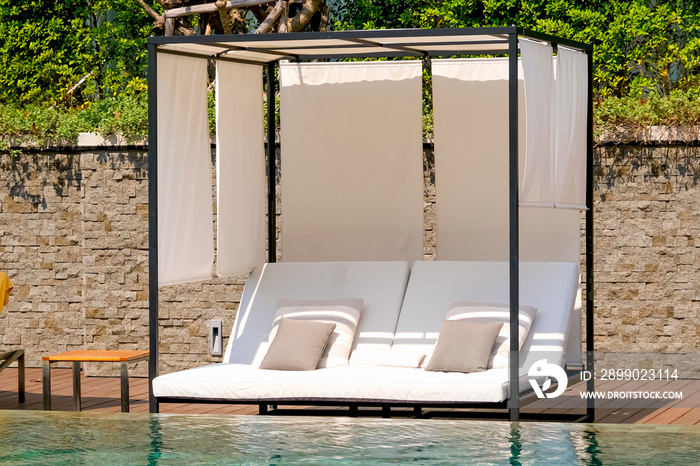 Chaise longue and swimming-pool. Leisure time near the swimming pool. Hotel business, travel concept