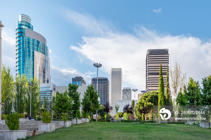 Skyscrapers in the center of Madrid next to a garden of green grass