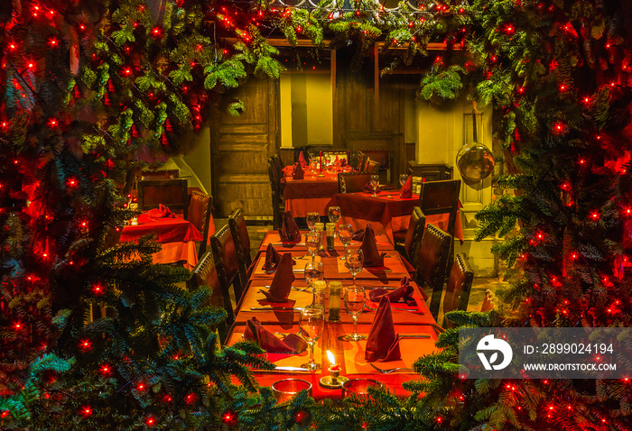 Christmas tree and fireplace seen through a wooden cabin window outdoor