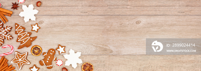 Christmas gingerbread cookies, candy and baking items. Top view corner border banner on a wood backg