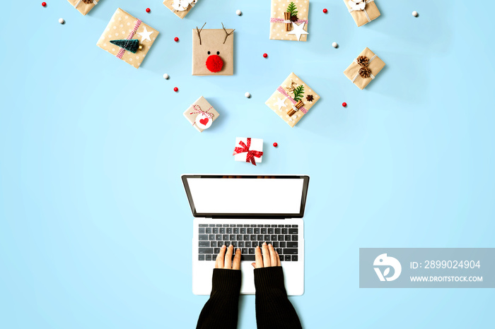 Person using a laptop computer with Christmas gift boxes from above