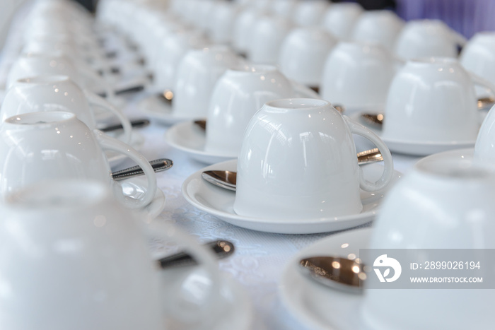 Group of many empty cups with spoons for service coffee or tea in seminar event or meeting room