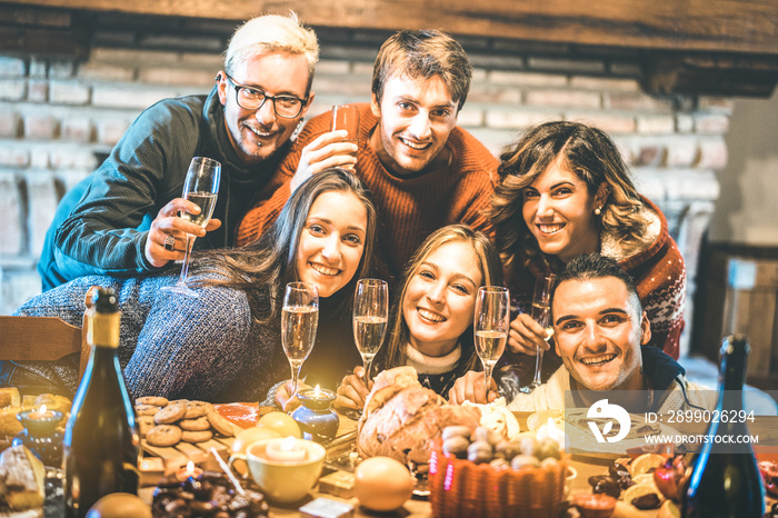 Happy friends on group photo selfie celebrating Christmas time with champagne and sweets food at din