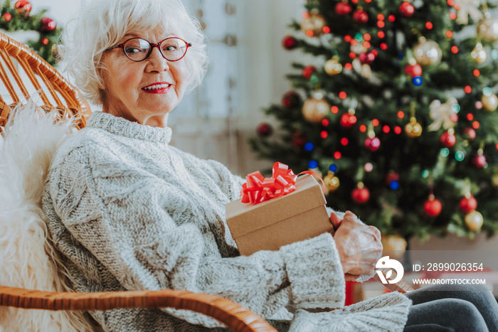 Old lady in glasses holding Christmas gift