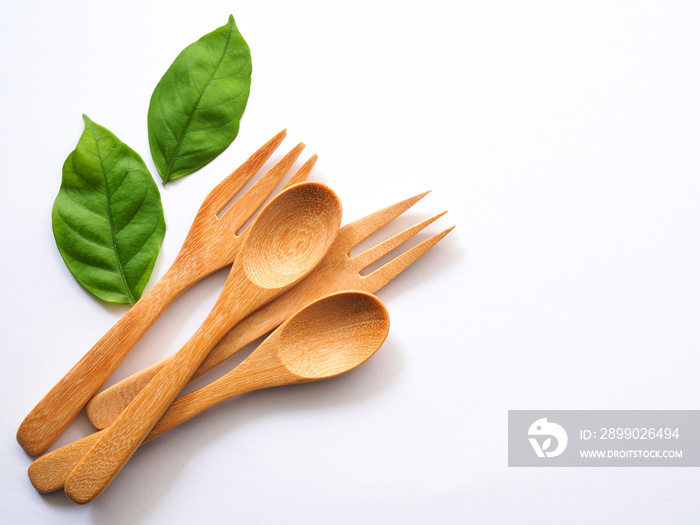 Wooden spoon and fork and green leaves, Natural wooden utensils Eco-friendly And safe for health Wit