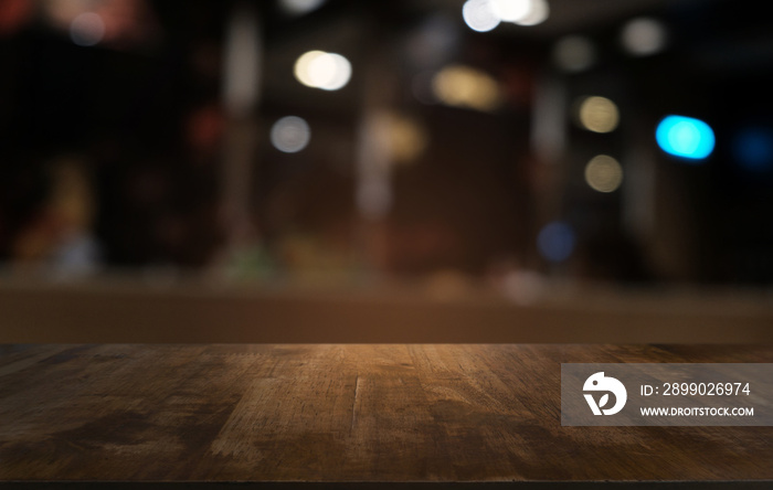 Empty dark wooden table in front of abstract blurred bokeh background of restaurant . can be used fo