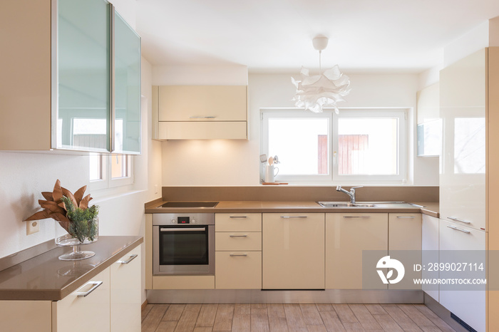 Clean and modern cream kitchen with large and bright windows