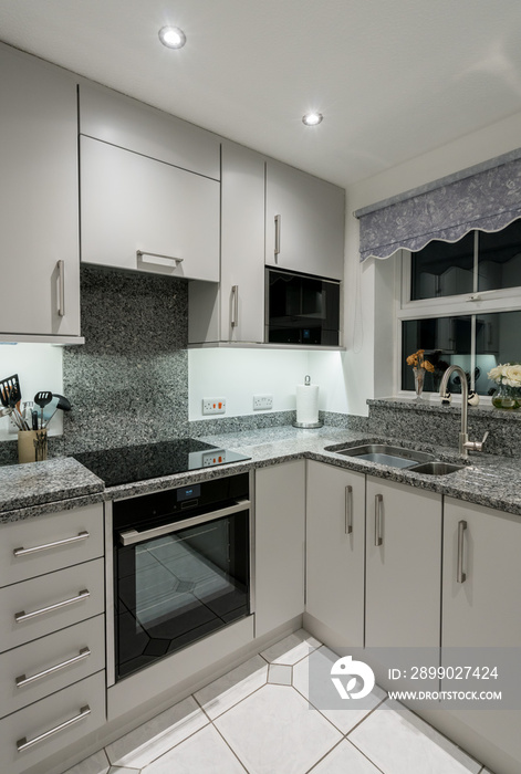 Small modern kitchen in apartment with granite worktop