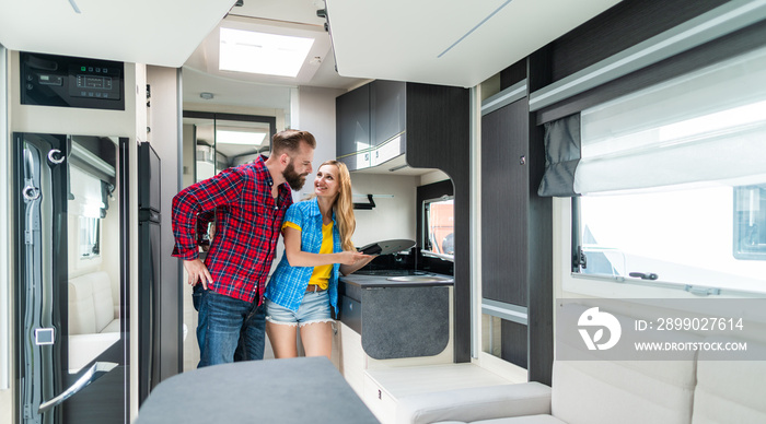 Woman and man testing interior of camper they want to buy or rent