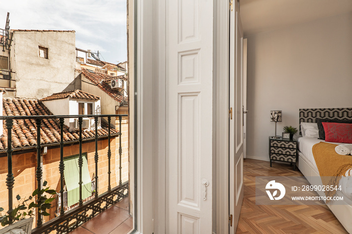 Bedroom with vintage white wooden balconies with black metal balustrade in the historic center of Ma