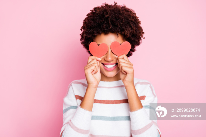 Photo of pretty dark curly skin lady holding in hands little red paper hearts hiding flirty eyes wea